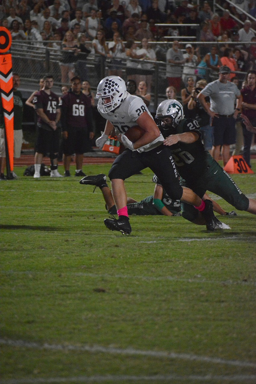 Pirates junior Travis Tobey (28) muscles his way for a first down.