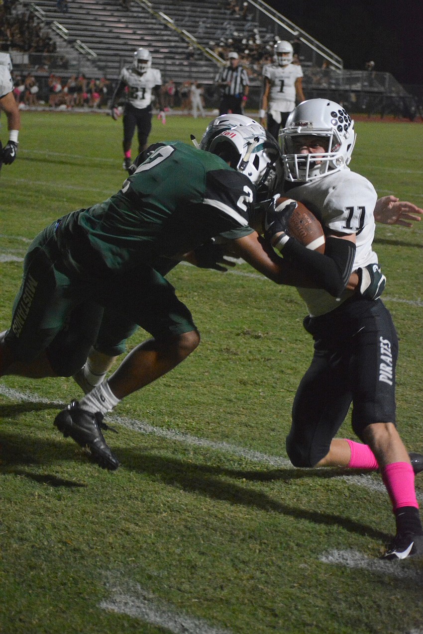 Lakewood Ranch senior Caleb Browner (2) lays a hit on Pirates junior Robbie Goecker (11).