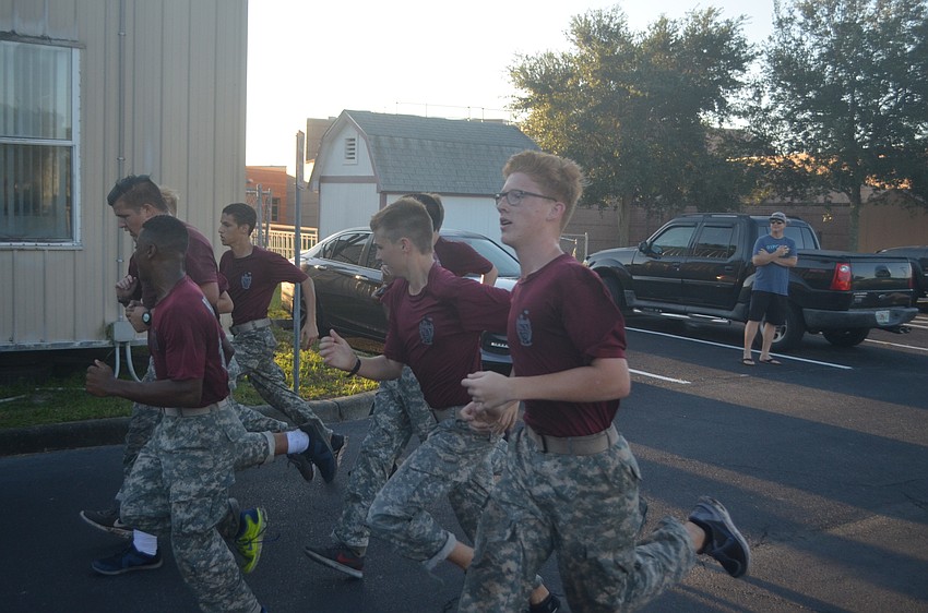 Freshman Hunter Miller from Braden River High School's JROTC men's team races across the finish line with his team.