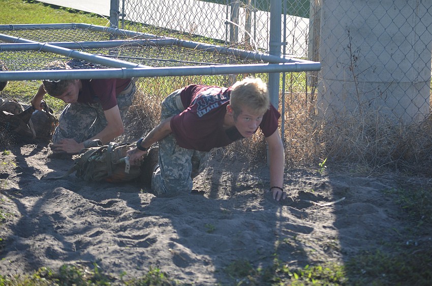 Sophomore Joseph Coyners and freshman Jacob Jackson from Braden River have to crawl under an obstacle at the end of their one mile run with their packs, and they could barely get their names out at the end of the race.
