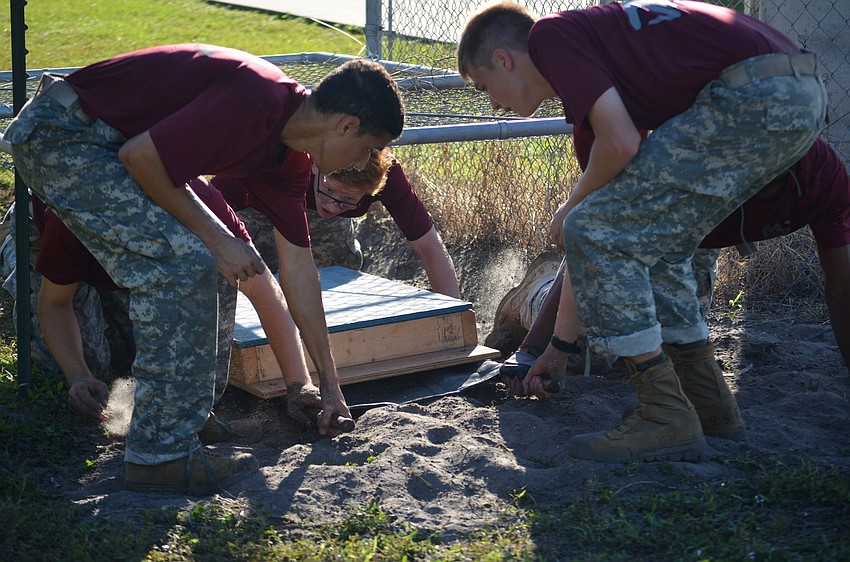 In order to pull the litter through the obstacle, senior Devon Avante, sophomore Hunter Miller and freshman Todd Jack have to work together to pull the litter through so the rest of the team can climb through the obstacle.