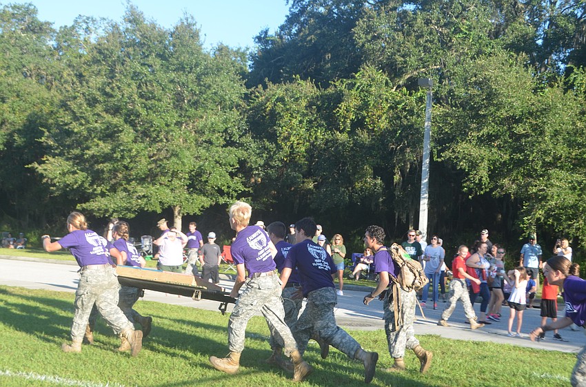 The entire Lakewood Ranch mixed team has to work together to carry a weighted gurney to simulate a body being carried for one mile. The weight of the gurney is 100 pounds.