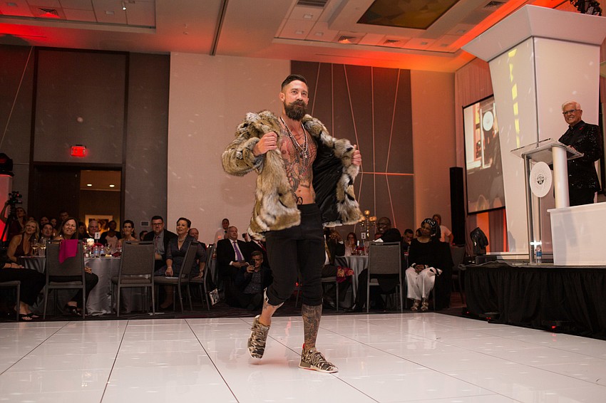 Dan Starostecki rips off his fur coat.