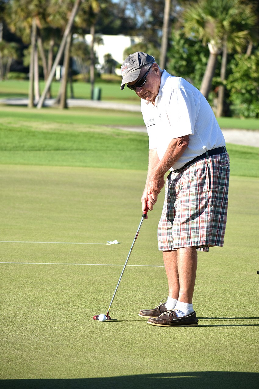 Town Commissioner Jack Daly starts off the putting challenge with a hole-in-one.