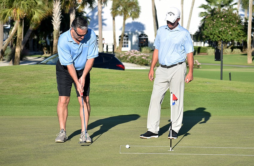 Longboat Key Club Director of Golf Terry O’Hara gives Longboat Key Fire Rescue Chief Paul Dezzi advice as he putts.