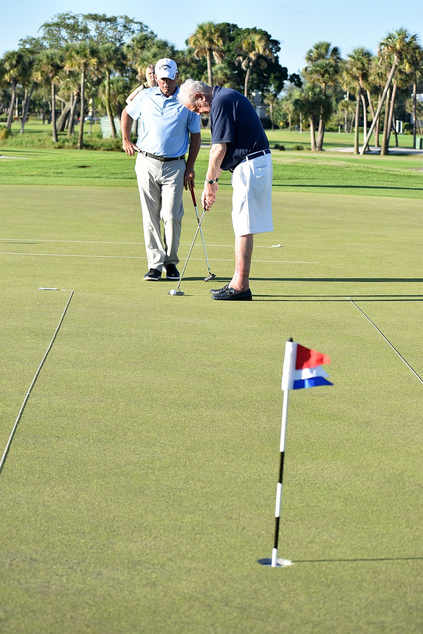 Mayor George Spoll readies his stance before putting.