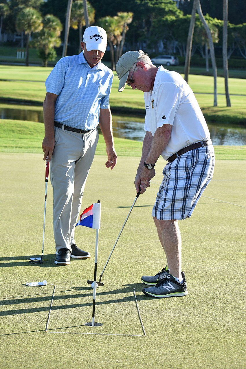 Longboat Key Club Director of Golf Terry O’Hara gives Commissioner Ken Schneier advice as he putts.