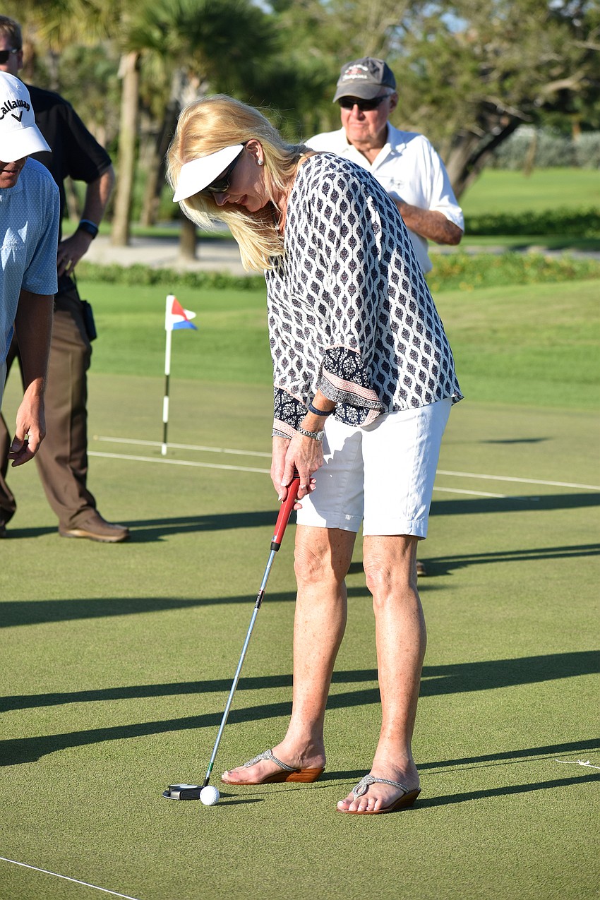 Assistant to the Town Manager Susan Phillips taps the ball into the hole.