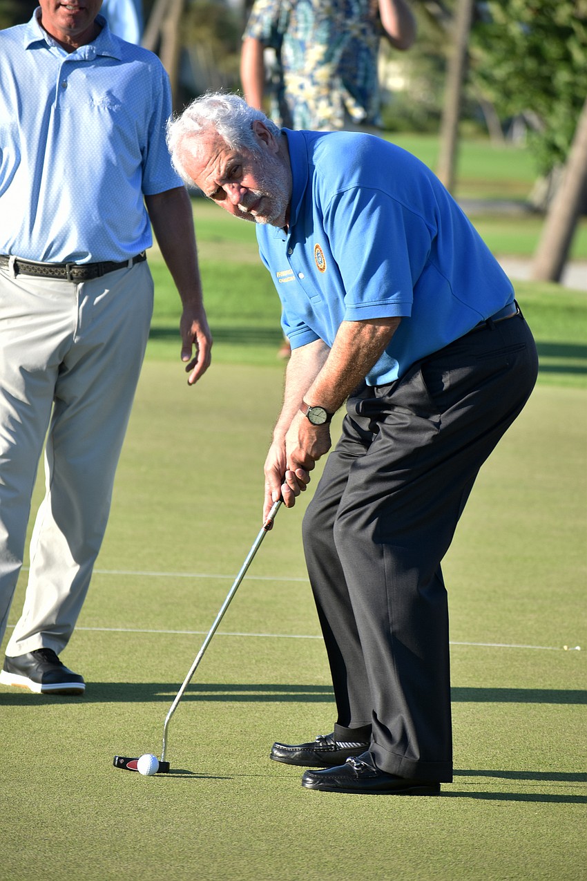 Commissioner Irwin Pastor takes his turn at the putting challenge.