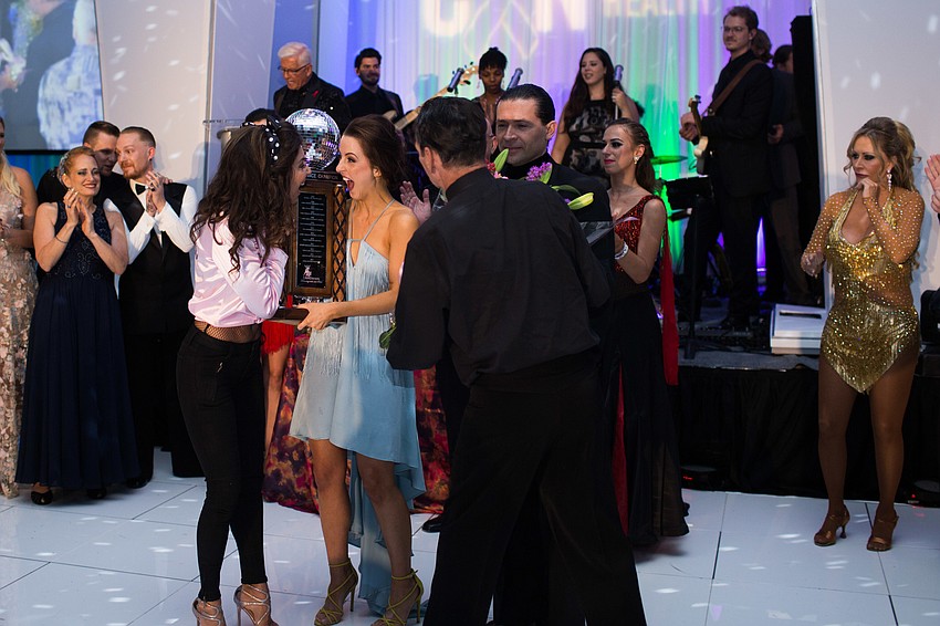 Previous CANDance winner Donna Koffman passes the trophy to Monica Kelly.