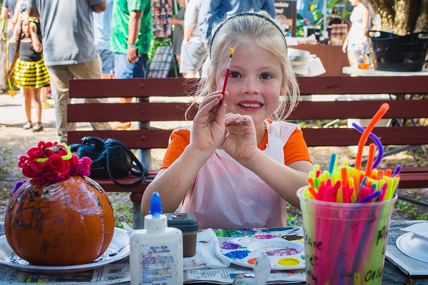 Harper Unkel paints a pumpkin.