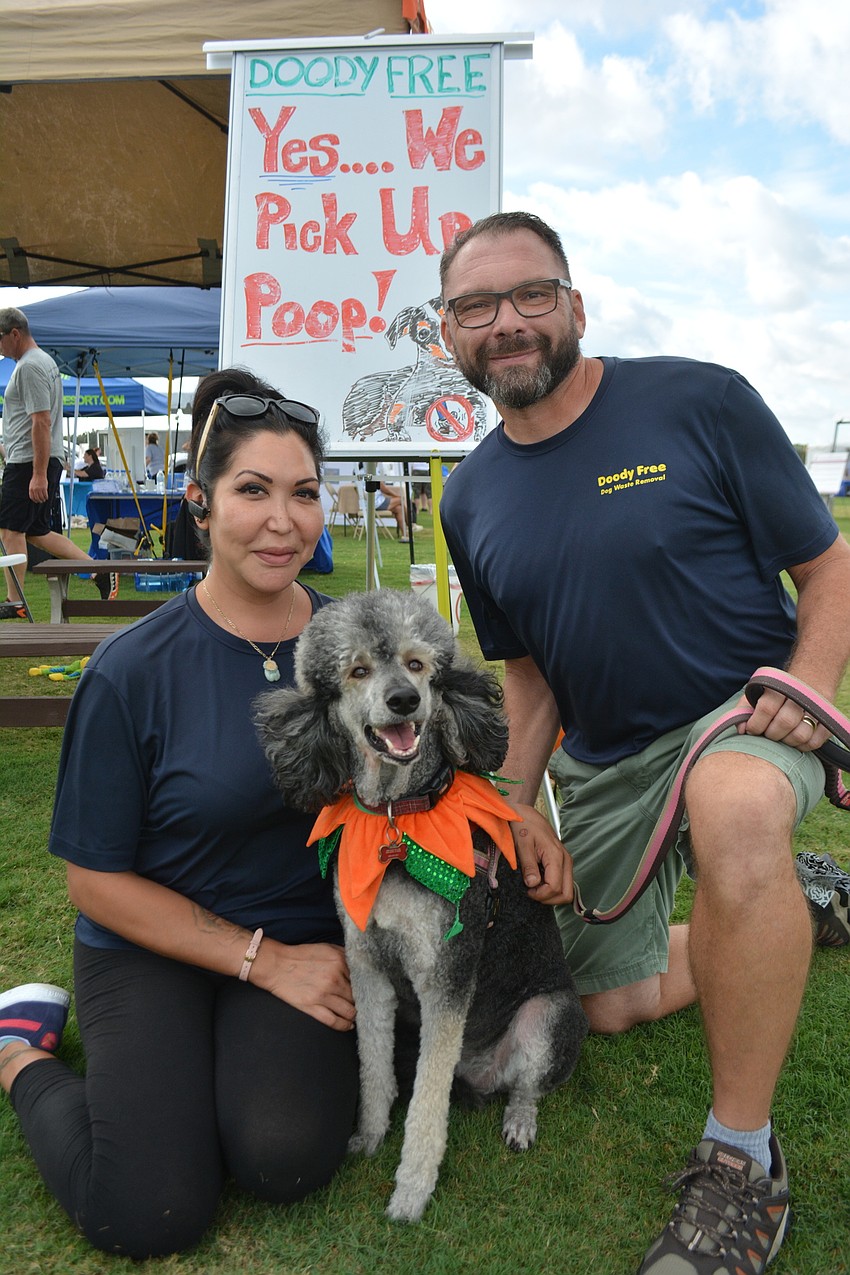 Via and Dave Karshick, owners of Doody Free, a Sarasota business that cleans yards of dog waste, pause with Pixie, their 4-year-old Standard Poodle.