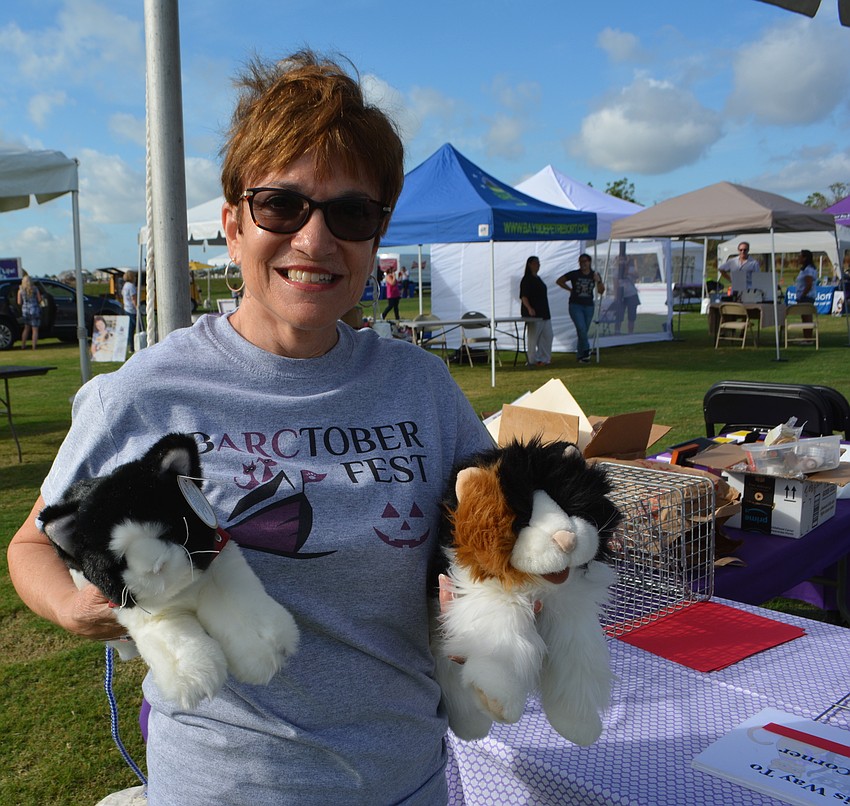Although the event was dominated by dogs, Animal Rescue Coalition volunteer Elaine Spang shows off two stuffed cats at a booth that was handing out cat information.