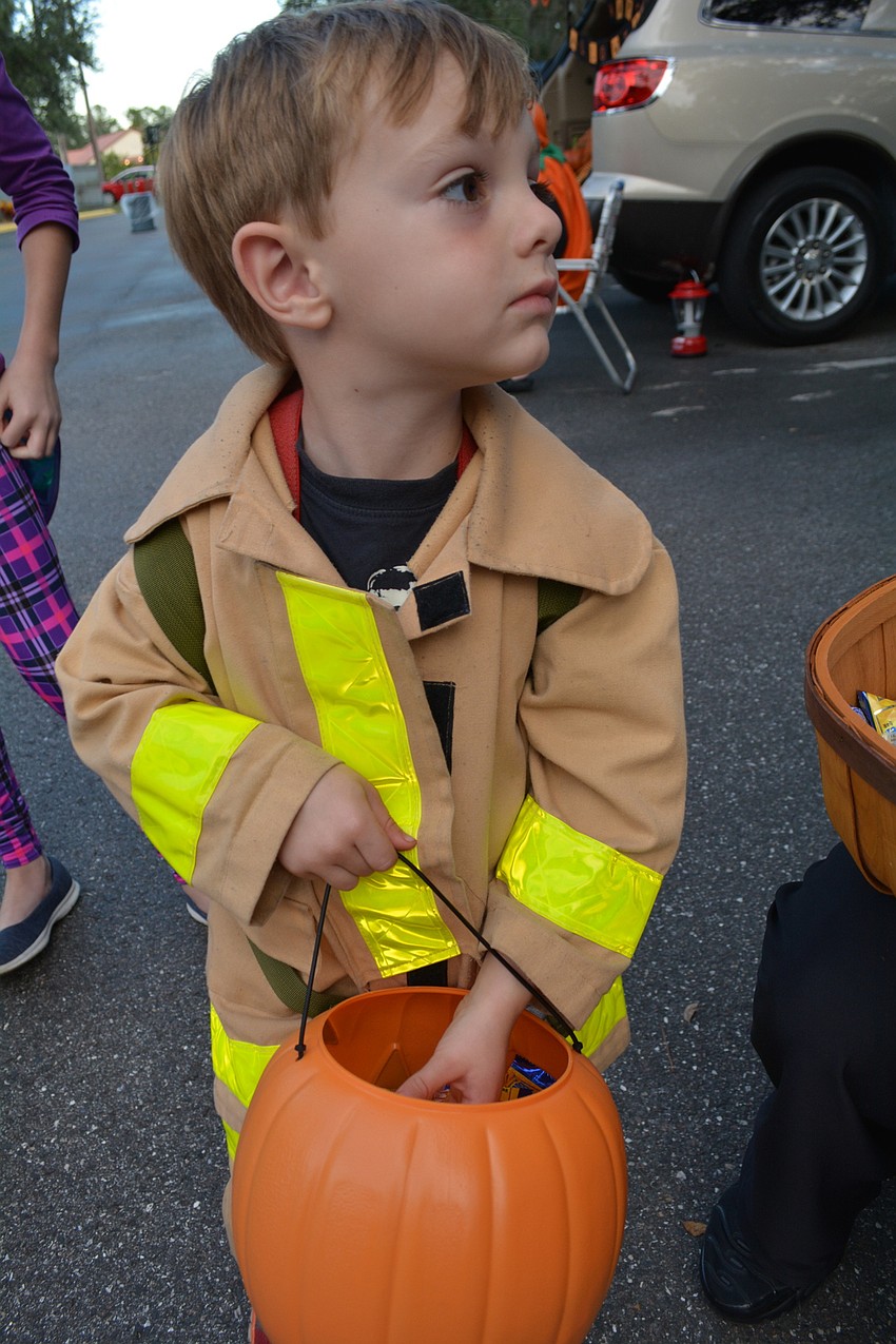 Four-year-old Colton White, of Myakka, shows off his firefighter outfit. An empty 2-liter bottle represented his air tank.
