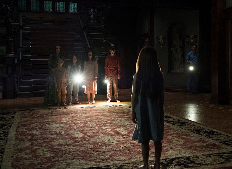The young Crain children and their parents turn their attention to Nell (Violet McGraw) in "The Haunting of Hill House." Photo source: Netflix.