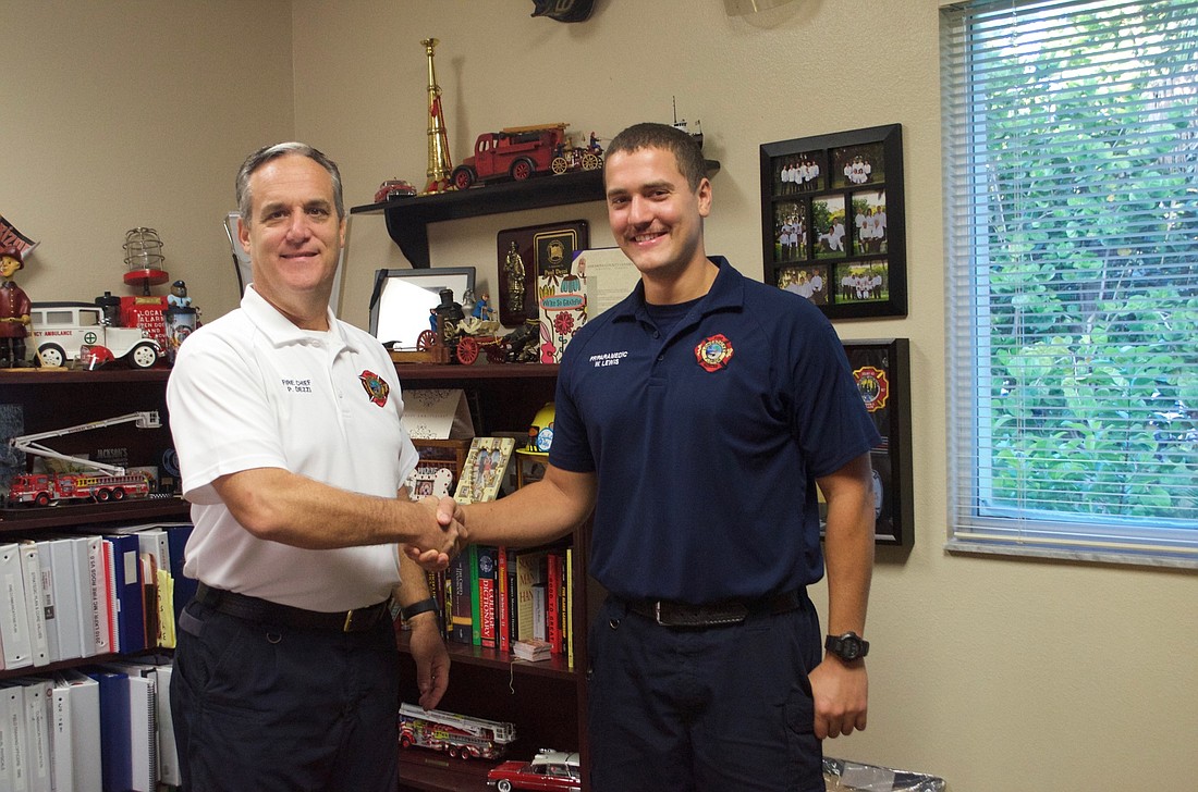 Chief Paul Dezzi congraulates William Lewis for assisting Hurricame Michael victims.