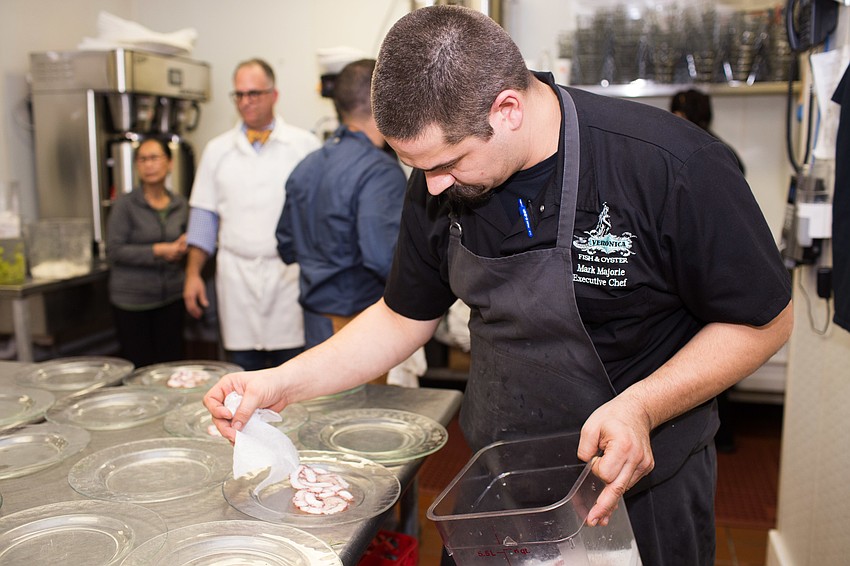 Chef Mark Majorie lays the octopus down on the plates.