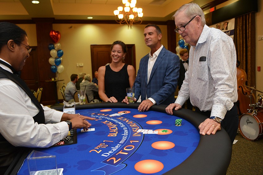 Essica Clemons deals Whitney Robinson, Michael Gilham and Rick Westhoff in a game of Black Jack.