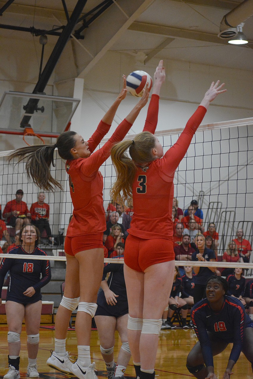 Skye Ekes (14) and Dalton Judge (3) leap to block an Oxbridge Academy shot away.
