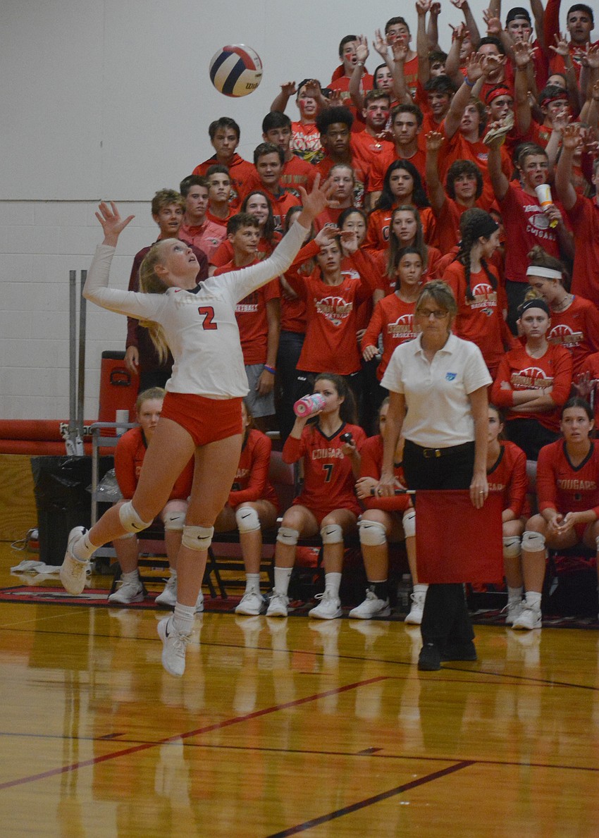 Madison Brown serves for the Cougars.