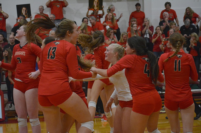 The Cougars celebrate after beating Oxbridge Academy in five sets.