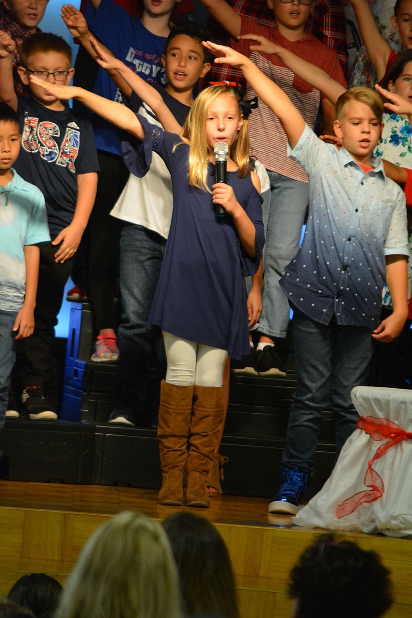 Isabella Miller and Ragan Wilson salute veterans and first responders before a slideshow begins.