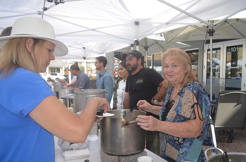 Lakewood Ranch's Mary Pat McSherry is served a kale and sausage soup by Cathy Hobora.