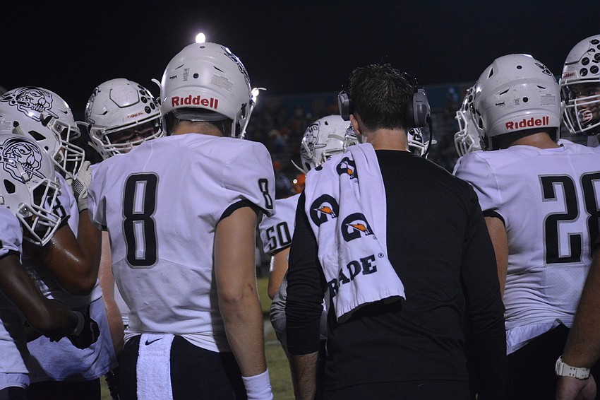 The Braden River offense, including Bryan Gagg (8) and offensive coordinator Eric Sanders, huddles together before a first-quarter drive.