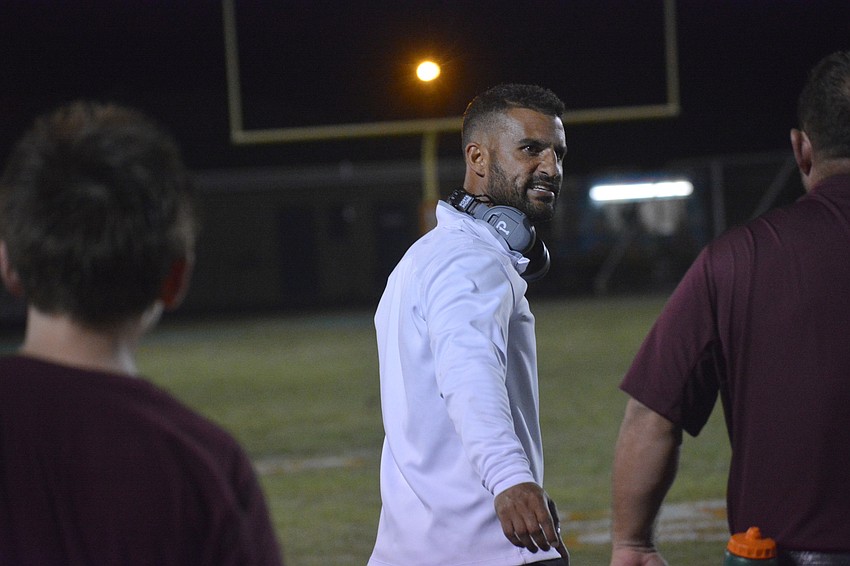 Head coach Curt Bradley gives instructions to his staff after the Pirates stopped the Raiders on a fourth and one run play for no gain.