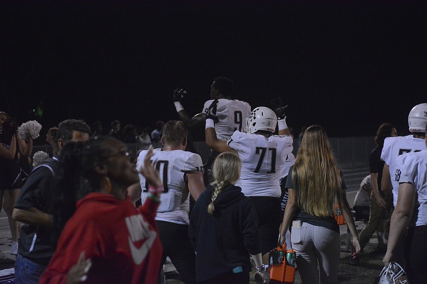 Junior defensive end Luke Reeves (10), senior linebacker Jesse Joseph (9) and junior guard Diego Alves (71) pump up the crowd as the clock winds down on the Pirates' victory.