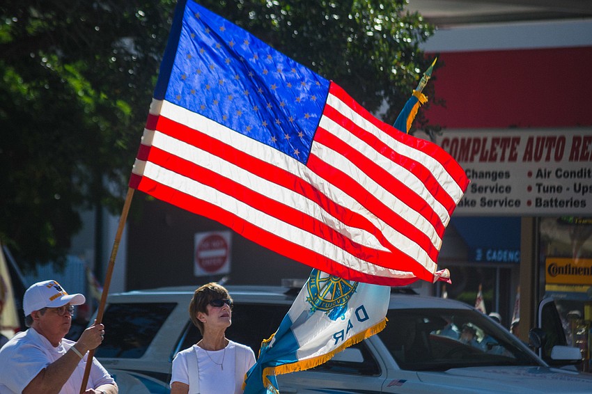 Parade attendees wave their flags.