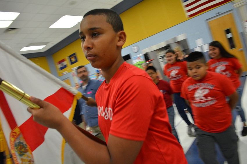 Fifth-grader Jose Reyes presents the colors at the beginning of the ceremony.