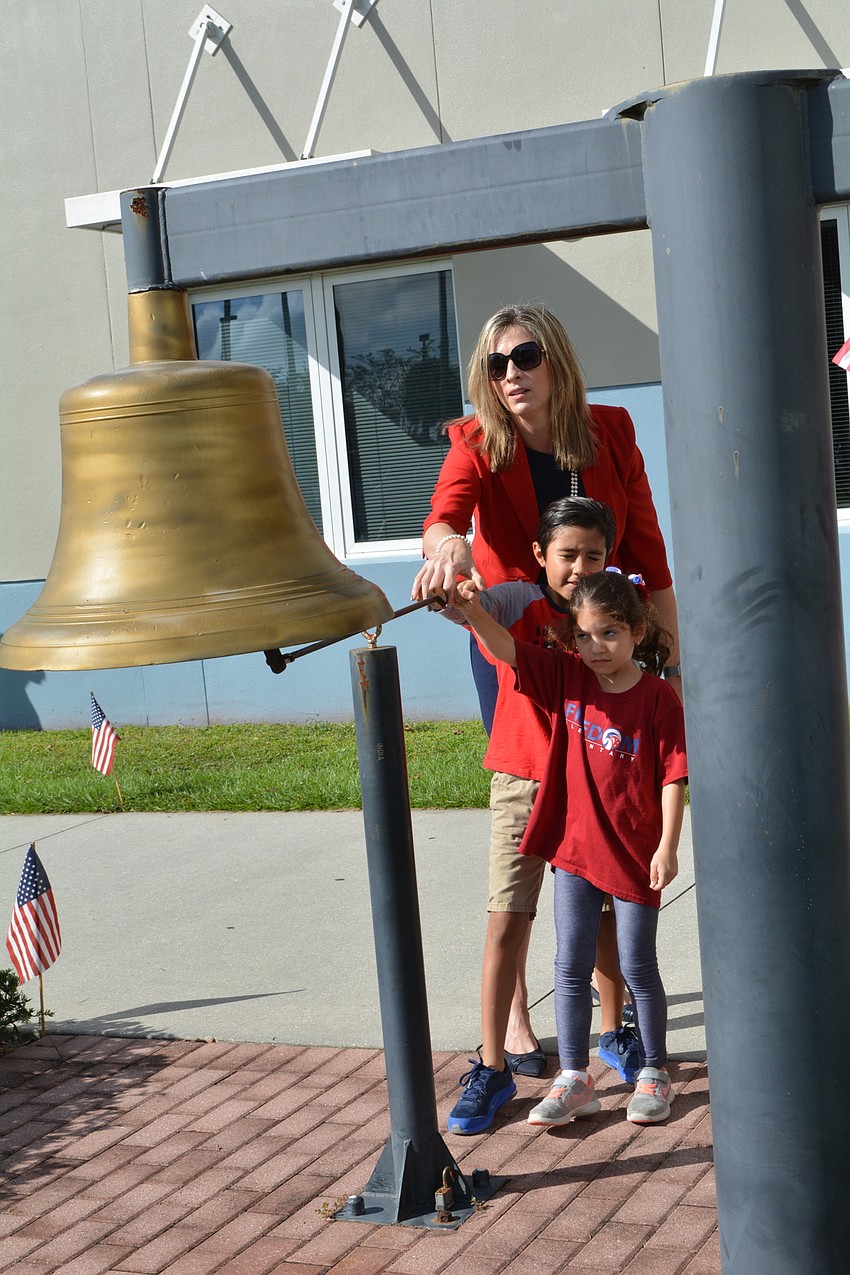 Edmundo Ramos and Olivia Llambes ring the freedom courtyard bell with the help of Assistant Principal Michele Danowski.