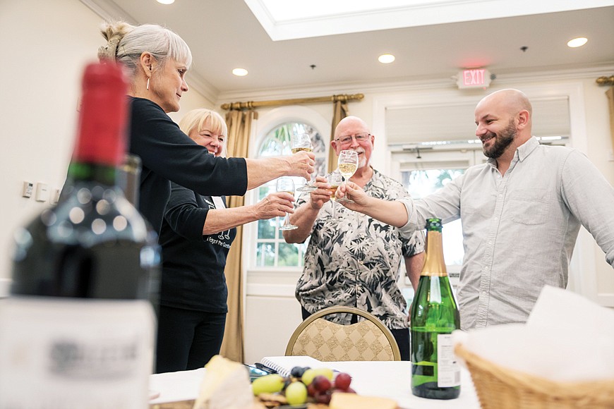 Kevin Allen (right) bonds with Corrine Wagner (left) and Maggie and Ron Magee over a bottle of chardonnay at a pop-up meeting of the Lakewood Ranch Wine Club.
