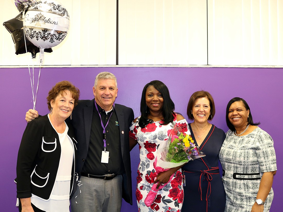 Assistant Superintendent and Chief Academic Officer Laura Kingsley, Executive Director of Secondary Schools Steve Cantees and Director of Leadership Carol Kay Brown led the charge for surprising Dr. LaShawn Frost, center