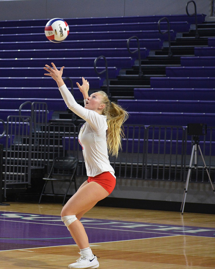 Cougars junior Madison Brown tosses a ball in the air for a serve attempt.