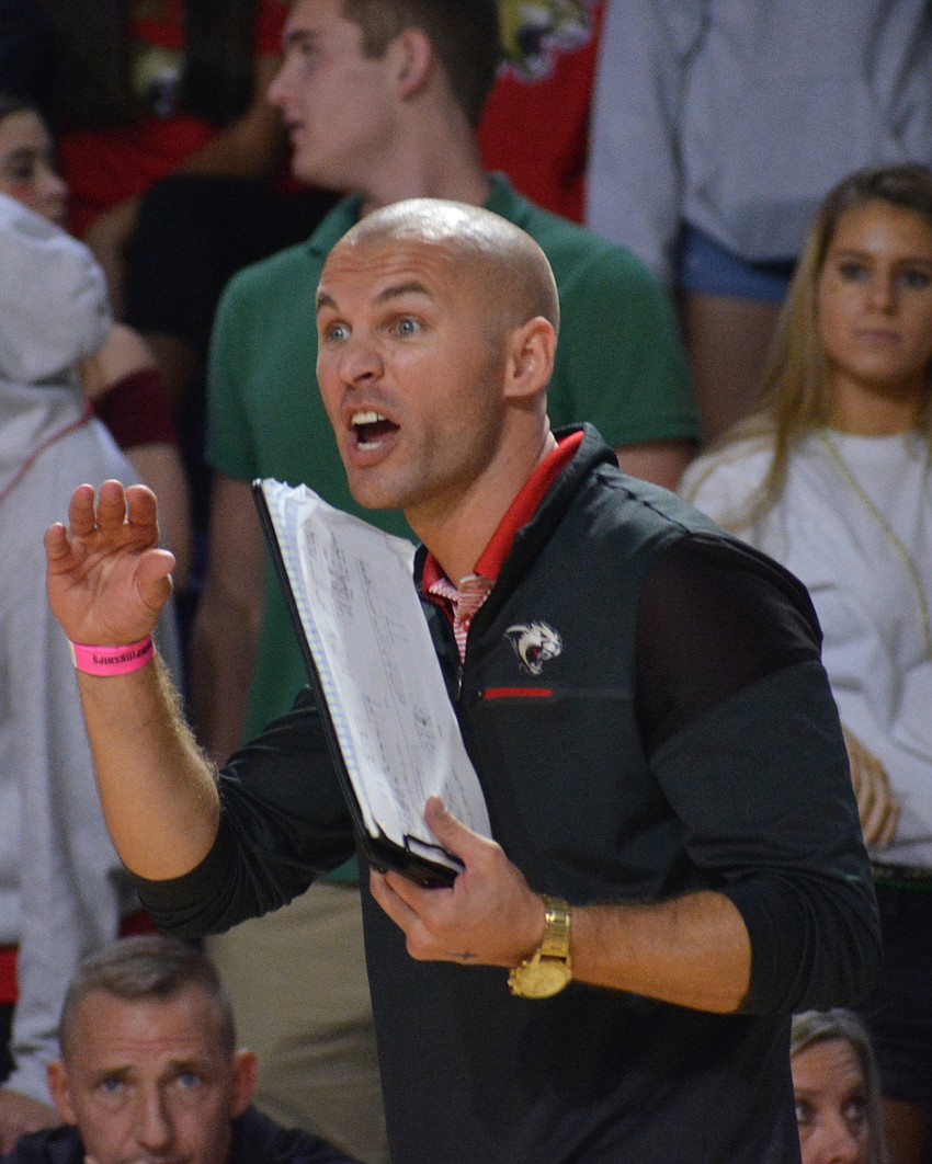 Cougars coach Chad Sutton gives his team instructions in the fourth set.