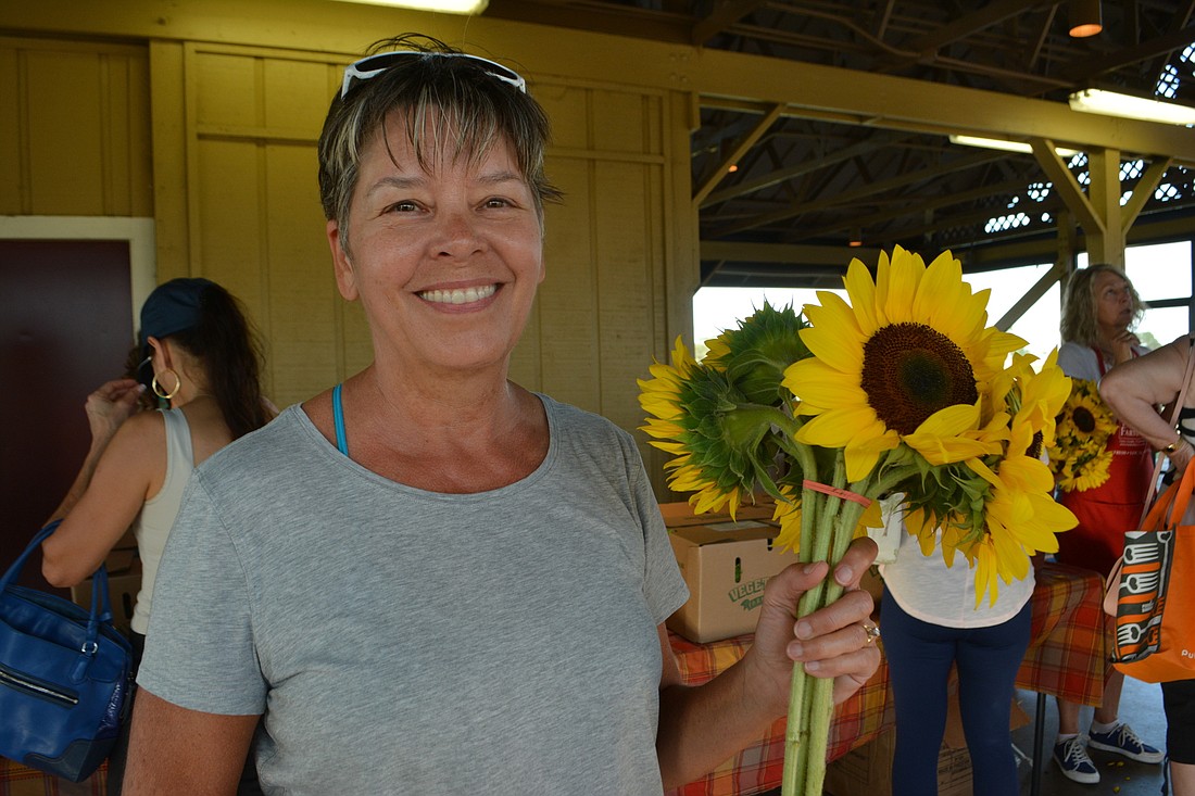 Becky LeVesque of Central Park shows off the sunflowers she picked up at The Market at Lakewood Ranch last year. File photo.