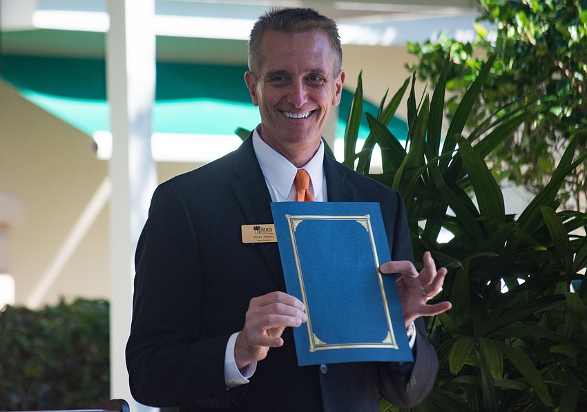 Pines of Sarasota Board Chairman Peter Abbott holds a proclamation from the city declaring Nov. 16 Pines of Sarasota Founders Day.