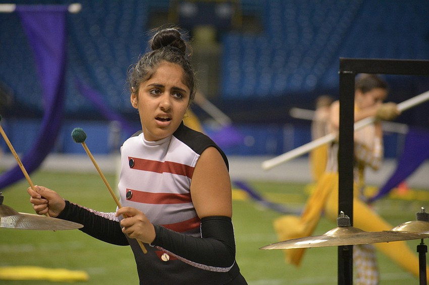 Senior Agila Patel watches for the direction of her drum major before playing her instrument.