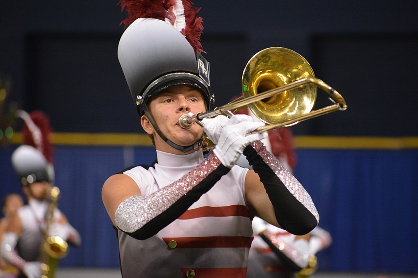 Clinton Engelberger, a junior, concentrates on playing the trombone while marching.
