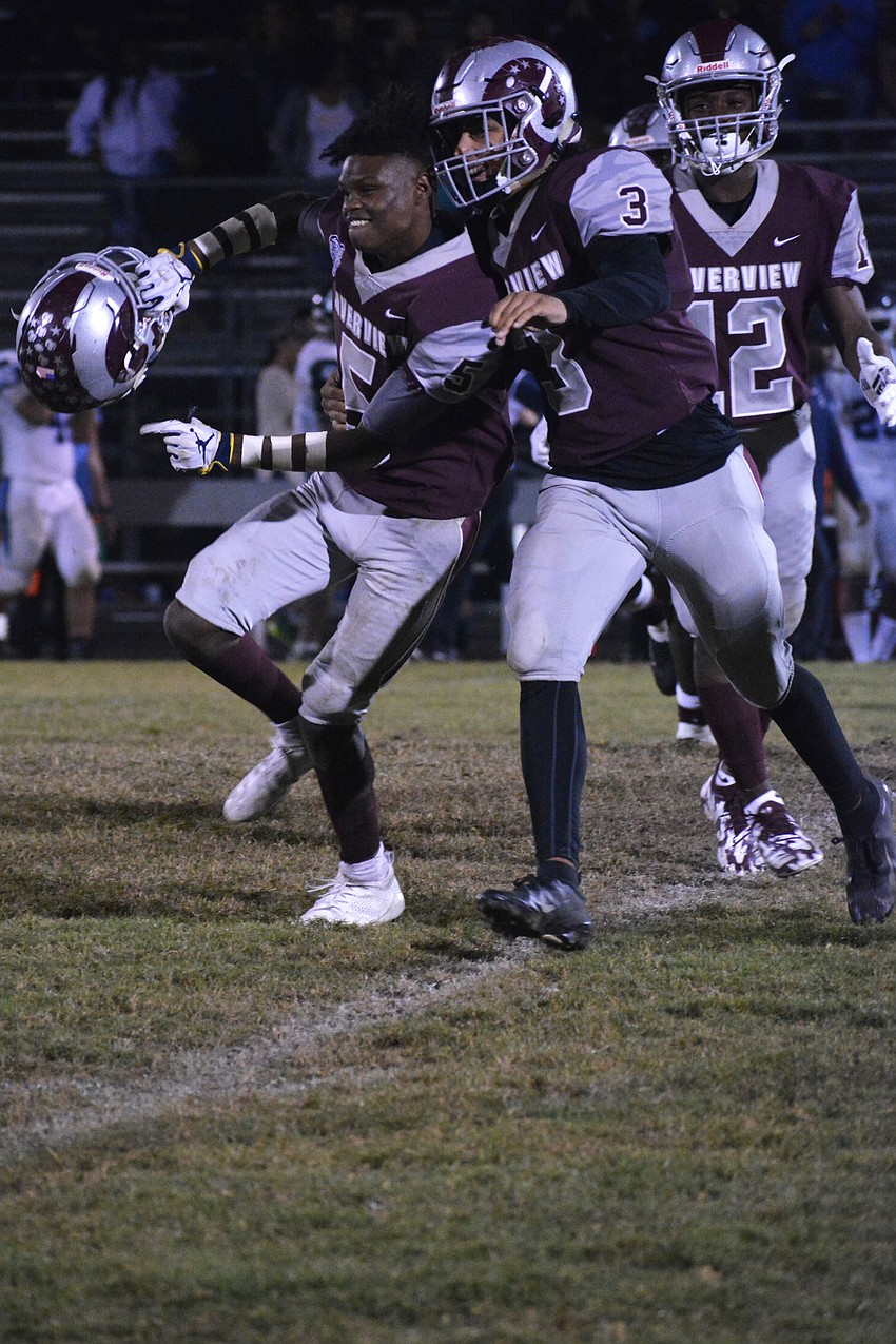 Charles Brantley (5) and Dylan Jenkins (3) celebrate Brantley's interception.
