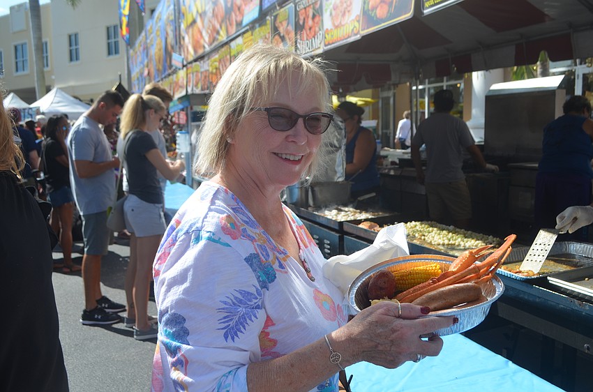 University Park's Doris Schnepel grabs a sampler platter of crab legs, shrimp and corn and potatoes.