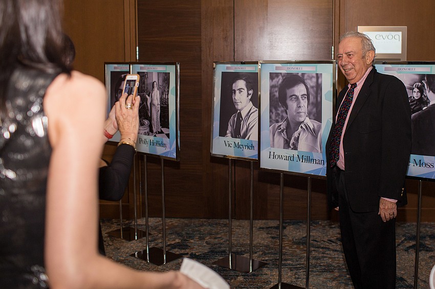 Honoree Howard Millman poses next to his photo.