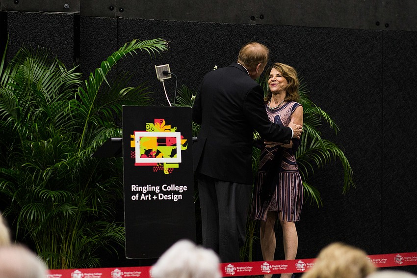 President Larry Thompson thanks Katherine Harris with a flower bouquet.