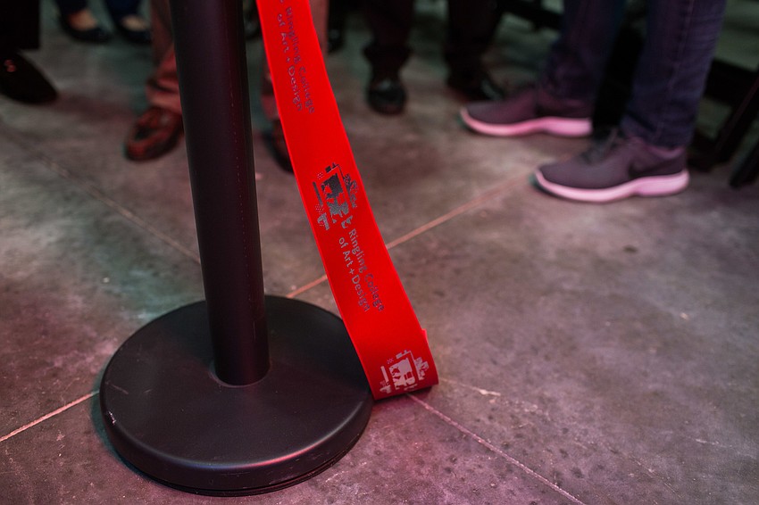 The traditional Ringling College of Art and Design way of cutting a ribbon requires the cutter to wear one white glove and use oversized gold scissors.