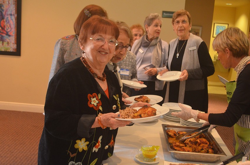 Diane Hart grabs some chicken with honey mustard drizzled on top.