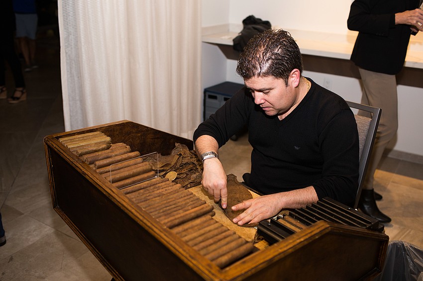A Cuban cigar roller demonstrates his trade.