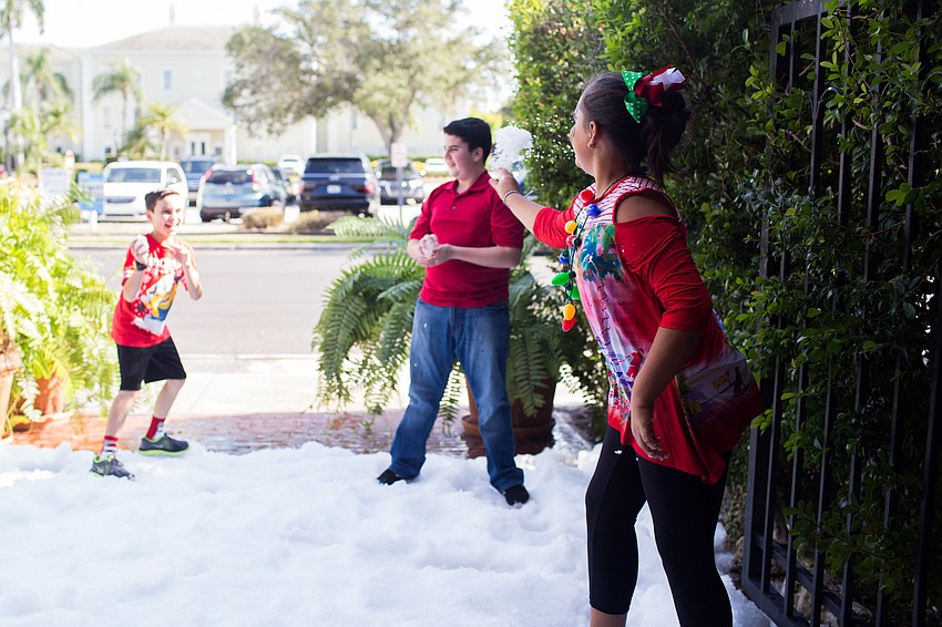 Kids throw snowballs at each other in the snow pit.