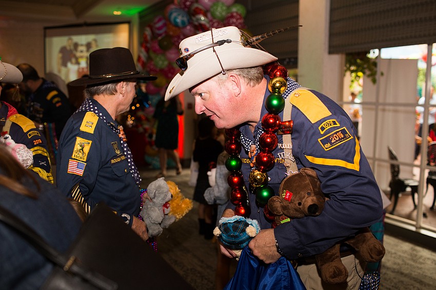 John Newton passes out stuffed bears to the children.